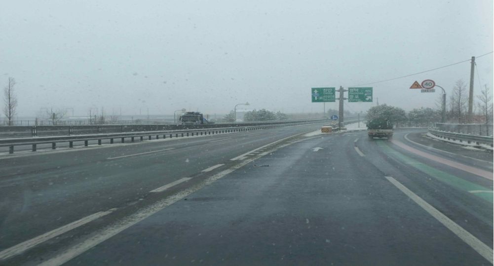 Snow is falling, so the road is slippery · Motorway · Moving toward the exit lane on the right