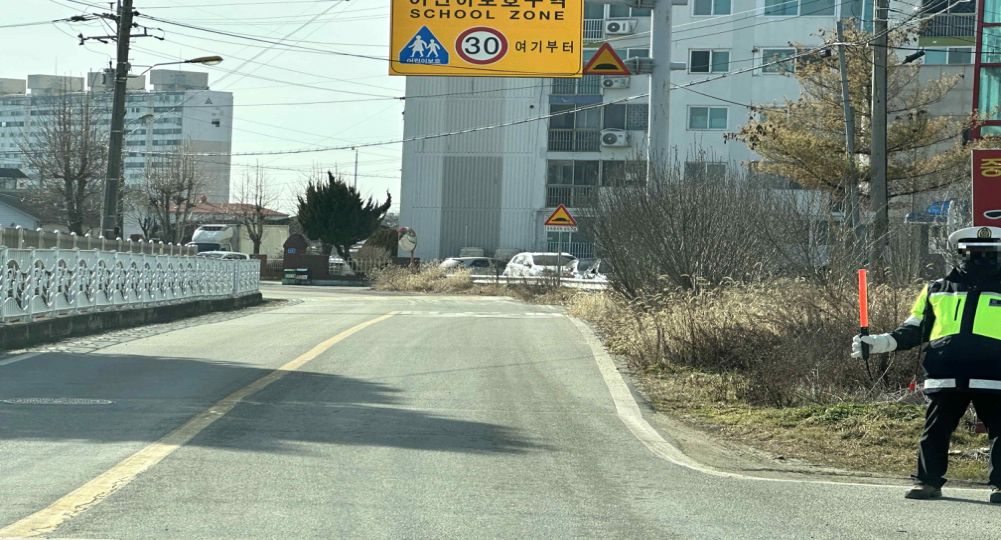 道路左侧为人行道 · 模范驾驶员(交通志愿者)正在指挥交通