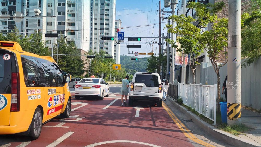One-way 2-lane road in a children's protection zone · Unprotected left turn sign at the intersection · Rider is traveling in lane 2
