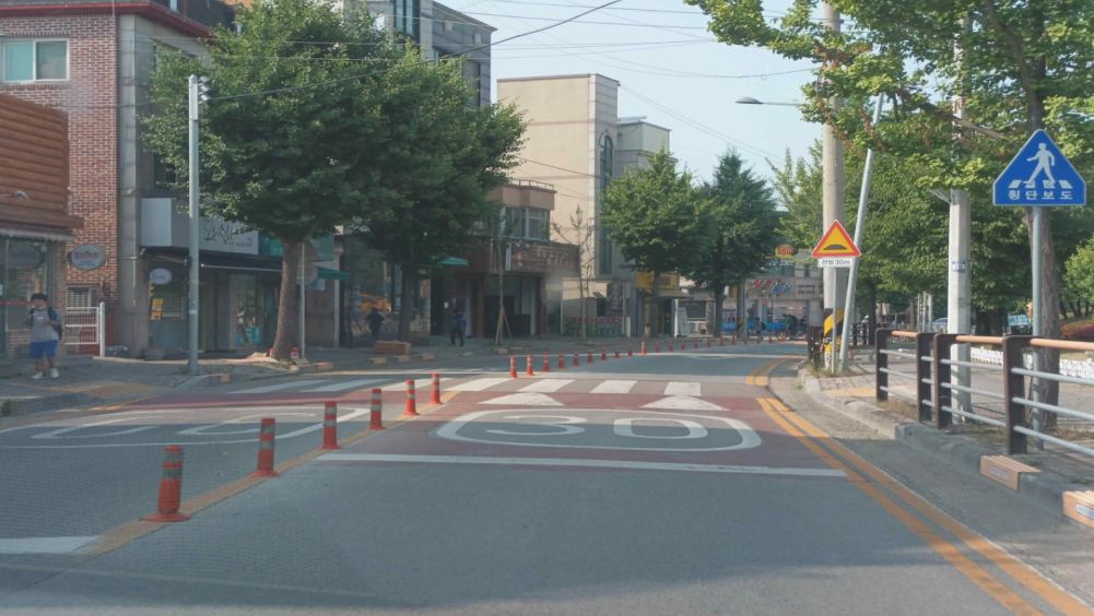 Crosswalk without a traffic light in front of a school · Children walking on the left sidewalk · Children's protection zone