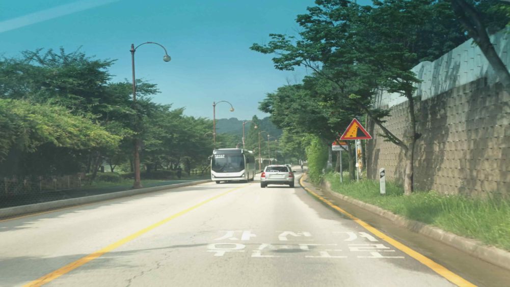 Bicycle priority road · Road surface partly wet with puddles · Falling rocks warning sign